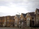 A 'for sale' sign in front of a row of homes in a subdivision in Vaughan, Ont.